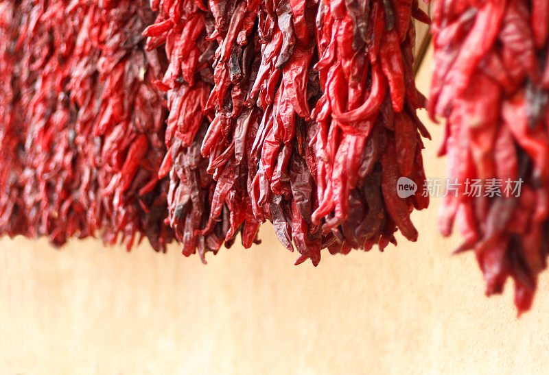 红辣椒Ristras Hung to Dry Against Adobe Wall, NM